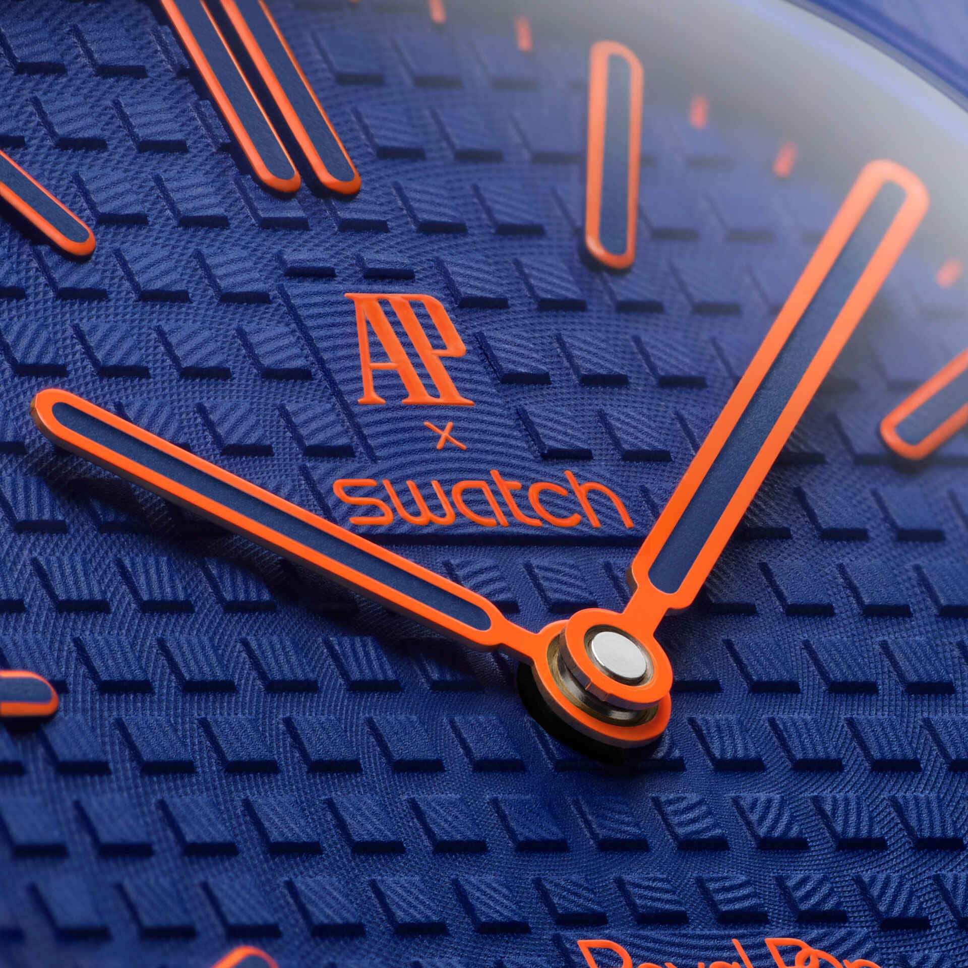 Détail cadran Royal Pop Orenji Hachi — motif Tapisserie bleu marine, logo AP x Swatch, aiguilles orange Super-LumiNova, couronne bleu marine