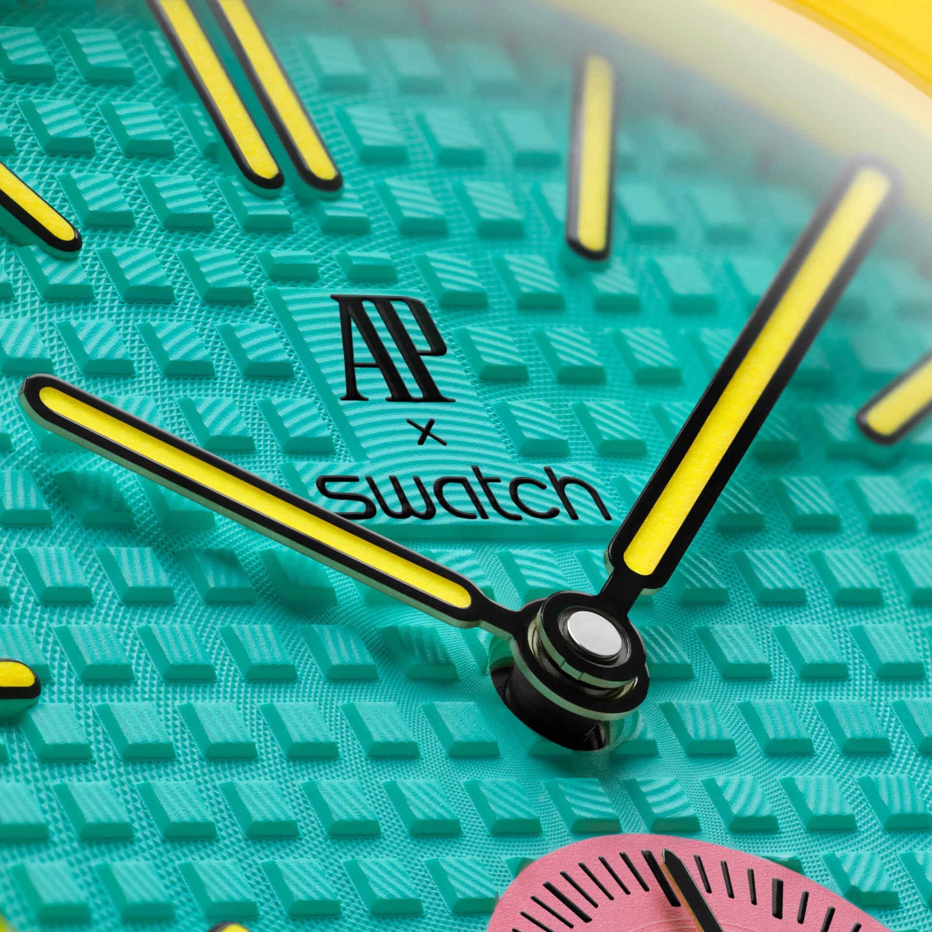 Détail cadran Royal Pop OTG ROZ — motif Tapisserie turquoise, logo AP x Swatch, aiguilles jaunes Super-LumiNova, couronne jaune à 3h